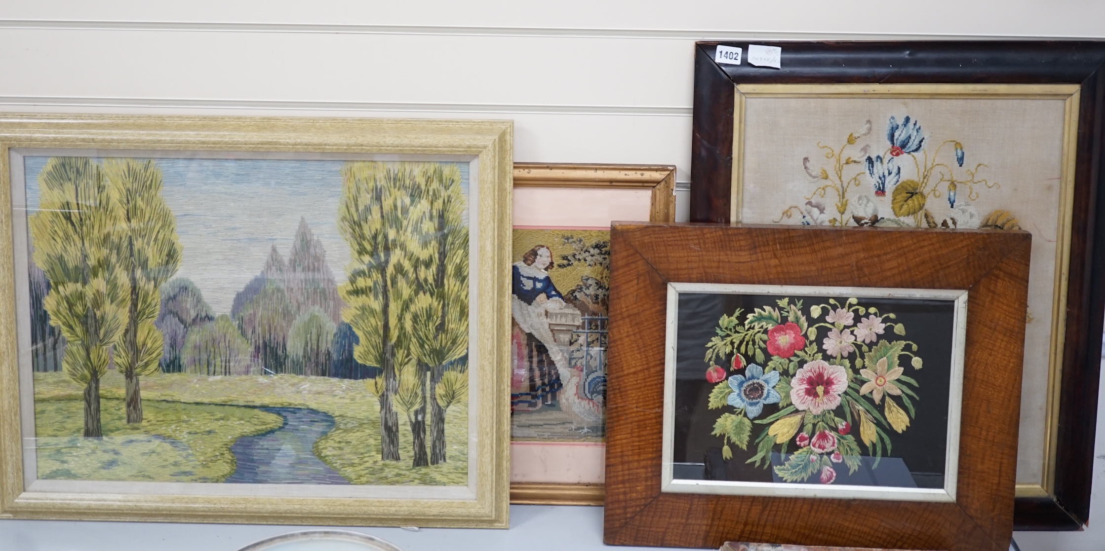 19th century and later framed embroideries (5); a 19th century wool worked still life embroidery, a later similar silk embroidery, a figurative wool worked embroidery, silk embroidery of a galleon and a landscaped wool w